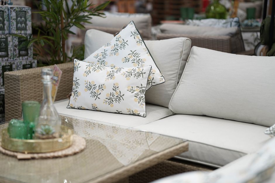 Witte regenbestendige buitenkussens in een zomerse tuin. Witte regenbestendige buitenkussens in een zomerse tuin.